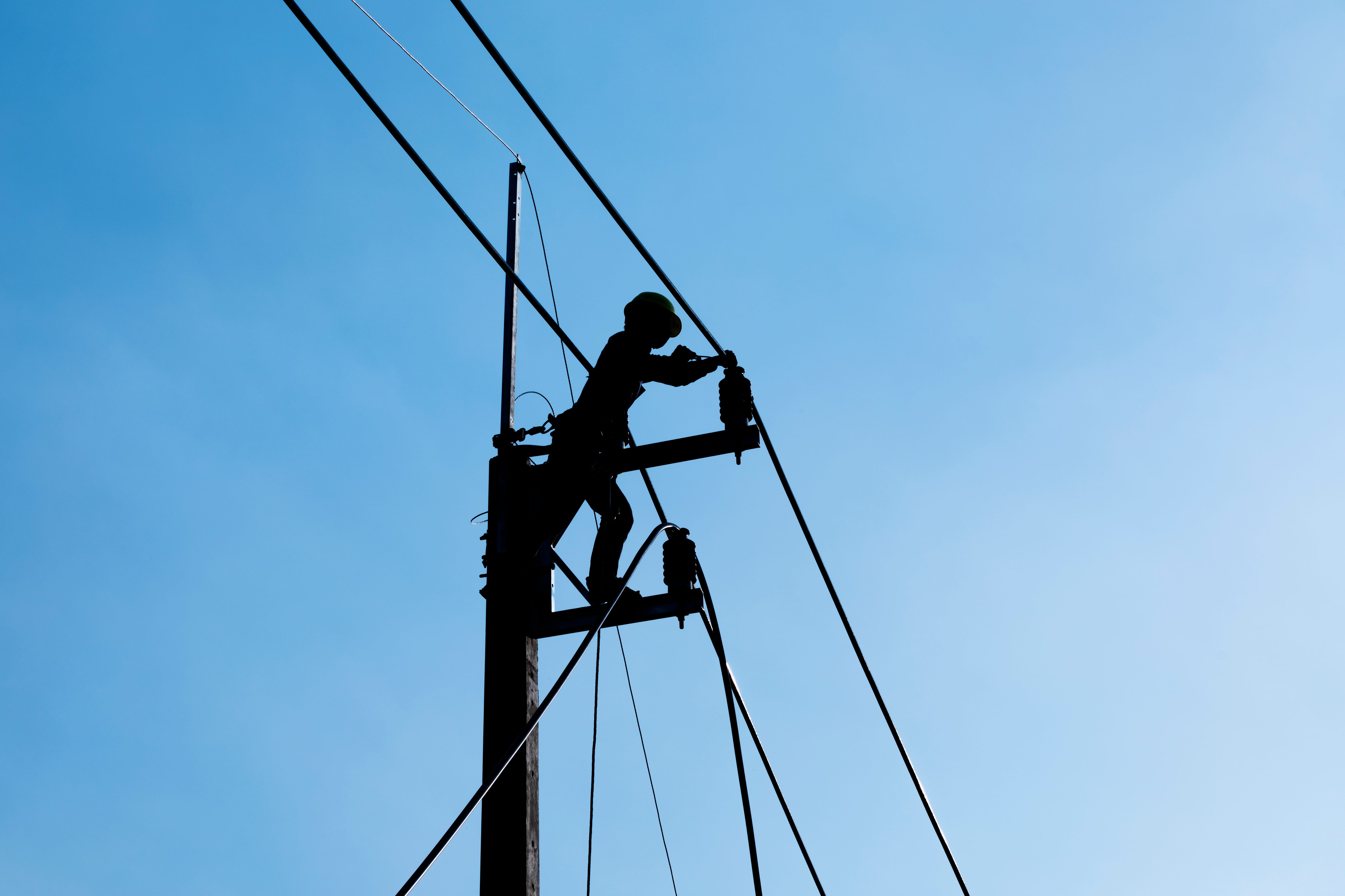 Silhouette,Electrician,Working,On,Electric,Power,Pole